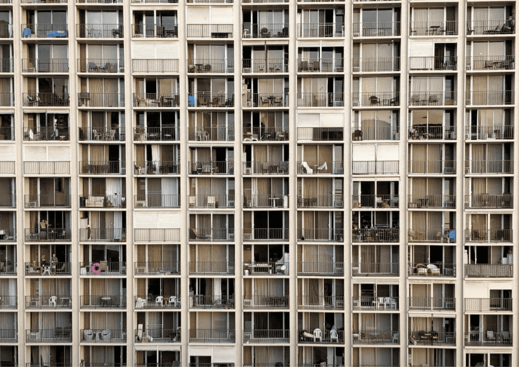 The front facing view of a block of flats, taken to show the individual windows and balconies.