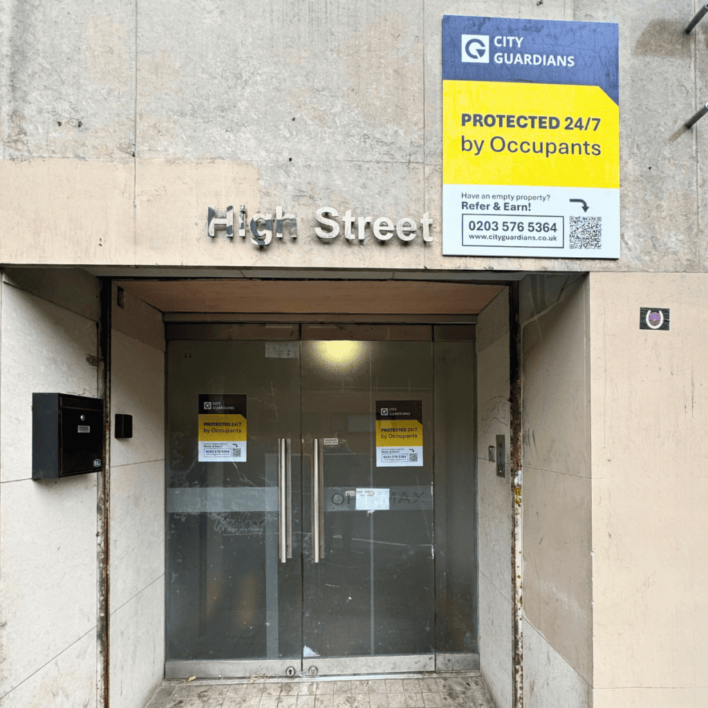 The front of the property in Croydon, it has glass doors, and a blue and yellow sign that reads: City Guardians, protected by City Guardians