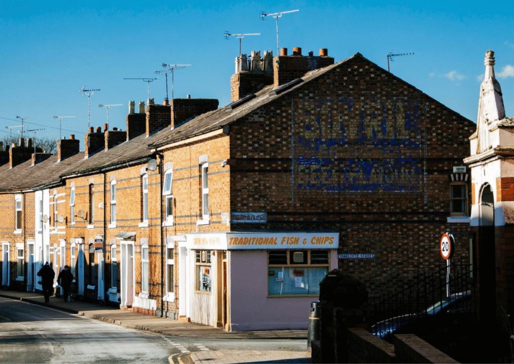 A street taken from an angle, showing a corner fish and chips shop.