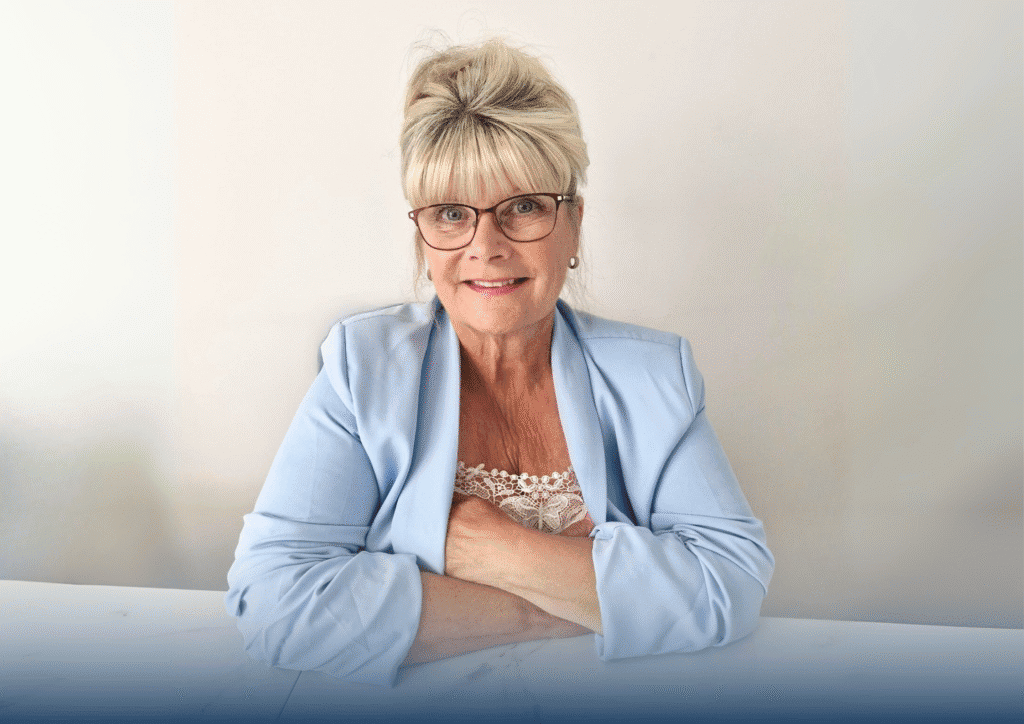 Karen, a woman with white blonde hair wearing a baby blue suit jacket sits against a white background