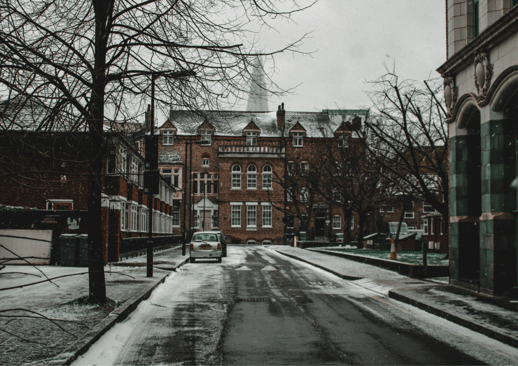 An icy street in London, showing old brick buildings and the shard in the distance