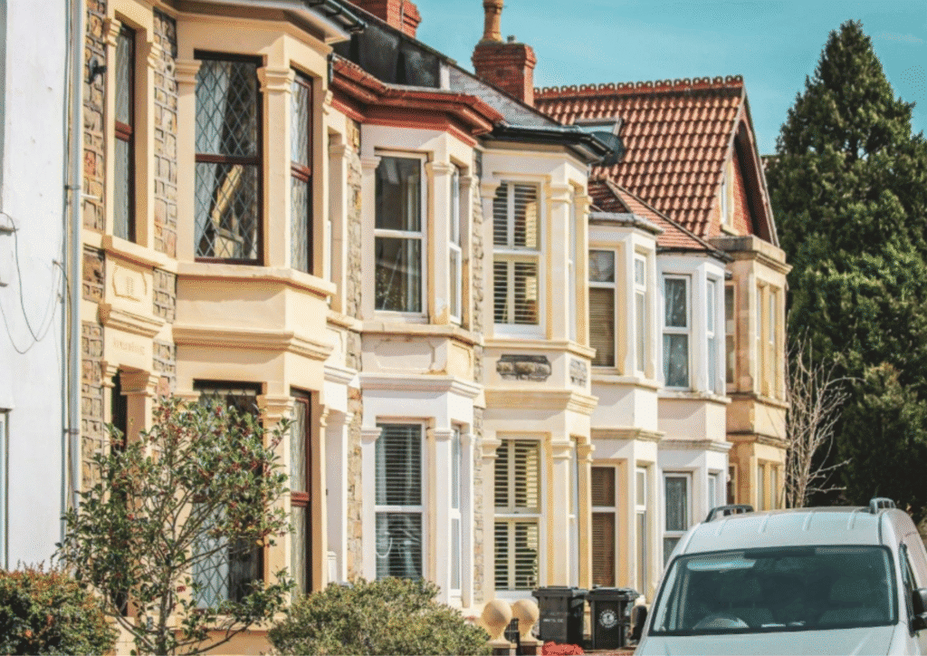 A row of houses with colourful windows and white stone exteriors.