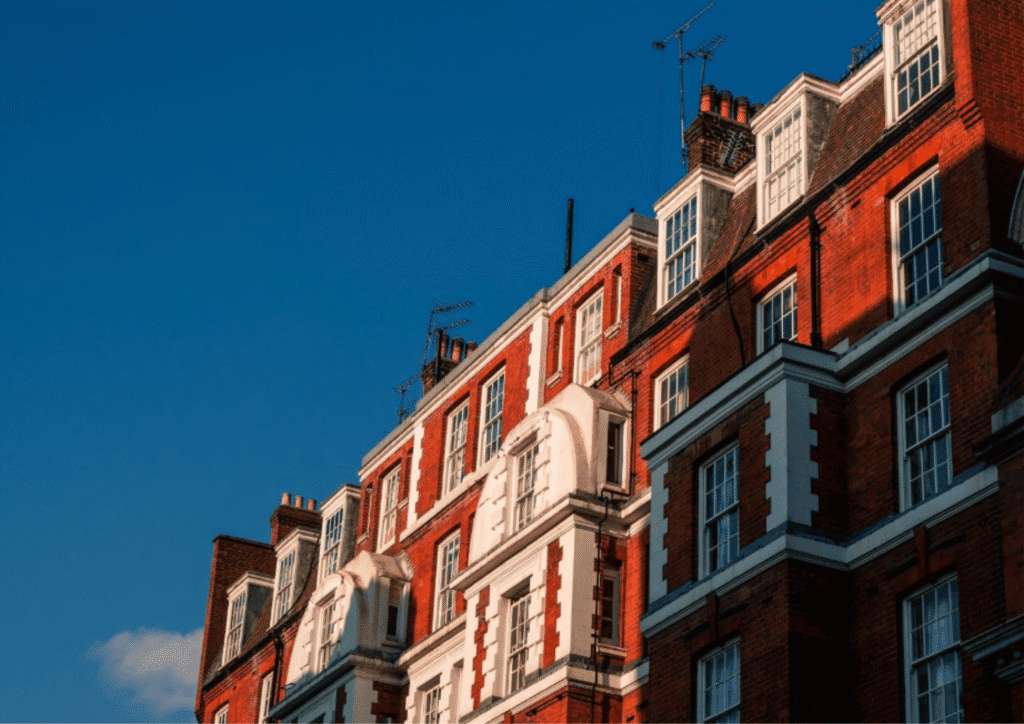 A red and white brick building angled with the blue sky above it.