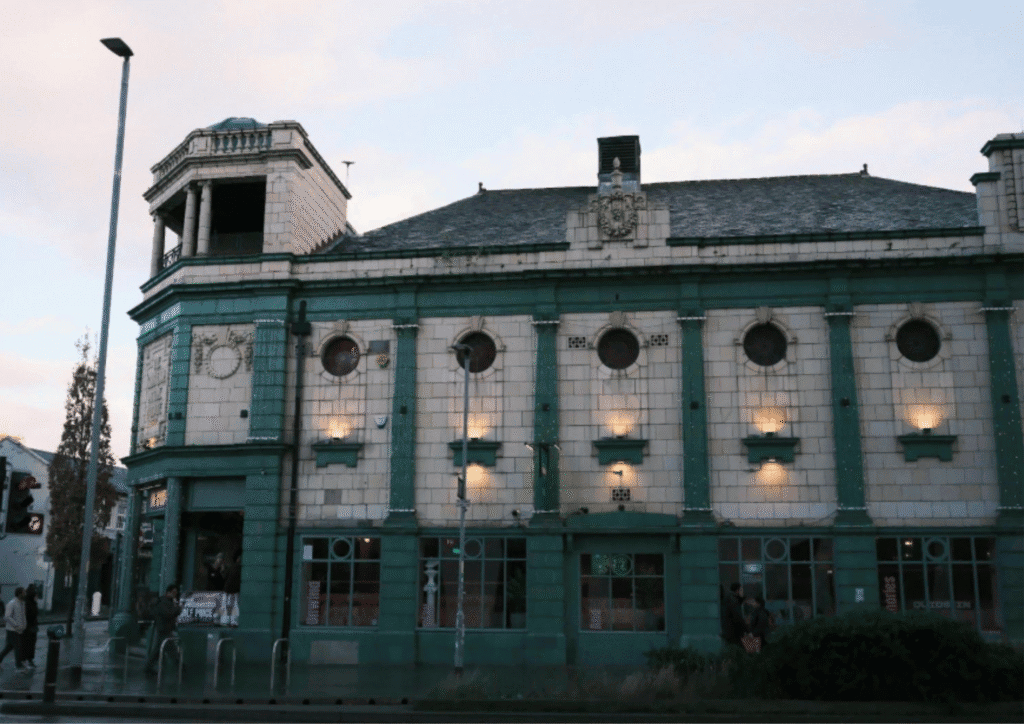 A blue and white tiled community building, shown at sunset