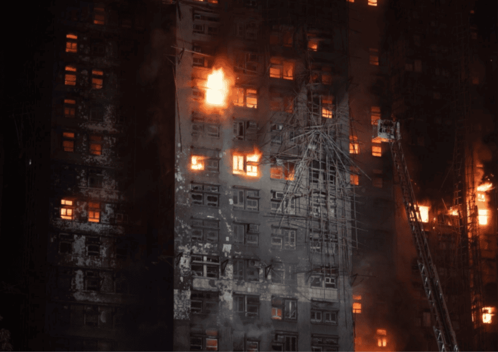 A tall apartment building on fire.